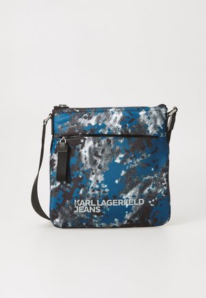 Blue and black patterned crossbody bag with a zip closure, featuring a textured surface and an adjustable strap. "Karl Lagerfeld Jeans" logo printed.