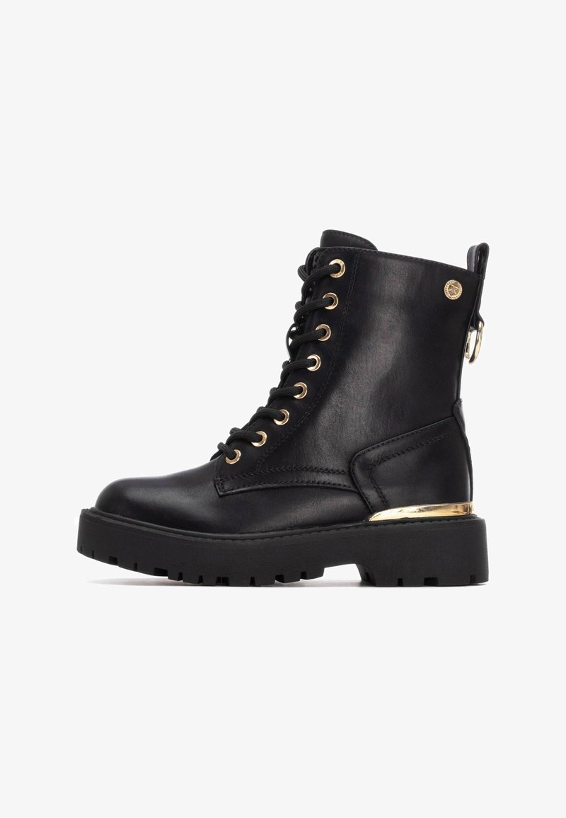 Botas de tobillo negras con cordones, hechas de cuero y con suela gruesa, adornos de hardware dorado y un lazo lateral para facilitar el uso.