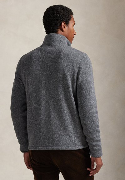 Γκρι φλις πουλόβερ με υψηλό γιακά, υφή επιφάνειας και μακριά μανίκια, με άνετη εφαρμογή και διακριτικές ραφές.