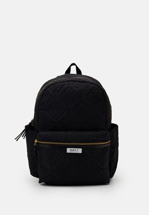 Sac à dos matelassé noir avec des zips dorés, comprenant une poche avant, un motif texturé et une poignée supérieure pour le transport.