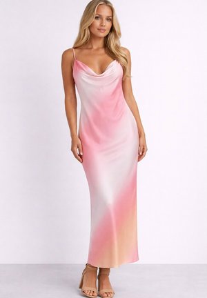 Femme portant une robe longue en satin sans manches avec de fines bretelles dans un dégradé de rose, blanc et pêche, associée à des talons beiges.