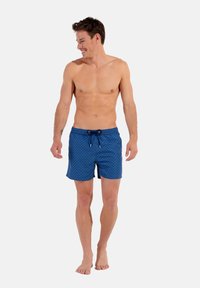 Shorts de bain bleus à motifs avec taille élastique et cordon de serrage. Fabriqués en matériau léger, présentant un motif en losanges.
