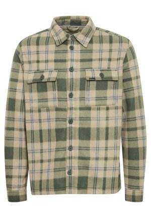 Roheline ja kreemjas ruuduline flanellshirt nööpide ja kahe rinnataskuga, samuti lõdva kaelusega. Pehme tekstuur ja standardsed pikad varrukad.