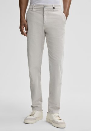 Light gray corduroy pants with a straight fit, featuring a button closure, side pockets, and a textured surface. Paired with white sneakers.