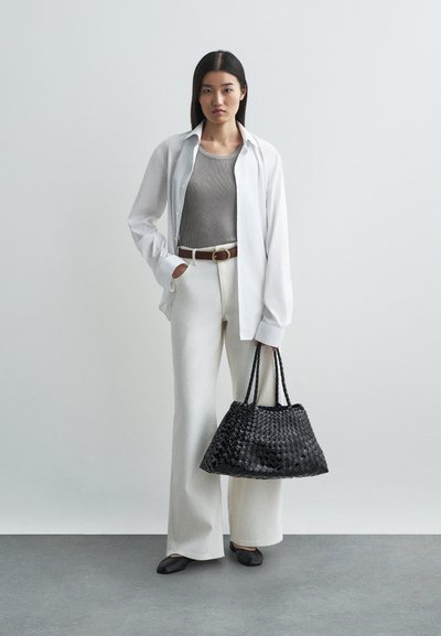 Nerti juodas rankinės, balti per dideli marškiniai, pilkas raguotas marškinėliai, šviesiai smėlio spalvos plačios kelnių, rudas diržas su apvaliu sagtimi, juodi butai.