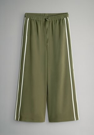 Olivengrønne shorts med hvide striber i siden, elastisk taljebånd, snoretrækdetalje og en glat, let tekstur.