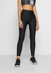 Svarta högmidjade leggings gjorda av mjukt, elastiskt tyg, med en åtsittande design, en subtil glans och inga synliga mönster eller detaljer.