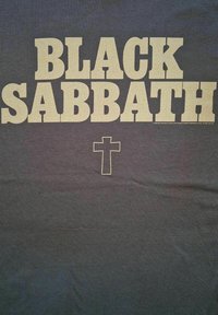 Svart t-skjorte med fete, kremfargede bokstaver som står "BLACK SABBATH" med et lite kors under teksten. Glatt tekstur.