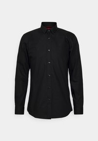 Camisa negra de manga larga con botones, hecha de algodón, que presenta un cuello con puntas, botones negros y un acento rojo en el interior del cuello.