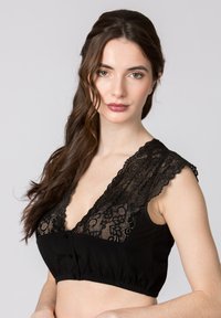 Schwarzer Bralette mit floralem Spitzenbesatz im oberen Bereich, Knopfverschluss vorne und einem elastischen Band für eine enge Passform.