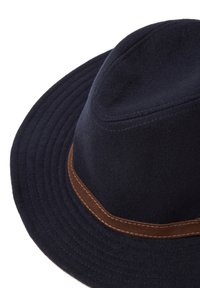 Cappello di feltro navy con una larga tesa arrotondata e una superficie texture. Decorato con una banda in pelle marrone con dettagli di cucitura visibili.