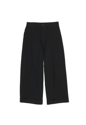 Mustad laia säärega lühikesed püksid voldikute, nööbi- ja tõmblukuga ning mansettidest ääristatud servadega valgel taustal.