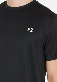 Svart t-shirt med kort ärm i mjukt material, med en vit "FZ"-logotyp på vänster bröstområde. Klassisk crew neck-design.