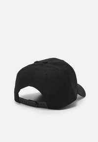 Casquette noire à forme structurée, fabriquée en tissu texturé. Elle possède une visière courbée, une fermeture snapback réglable et un bouton central sur le dessus.