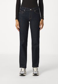 Tmavě modré denimové džíny s rovným střihem, pěti kapsami a kontrastním šitím. Mají zapínání na knoflík a zip, klasický střih.