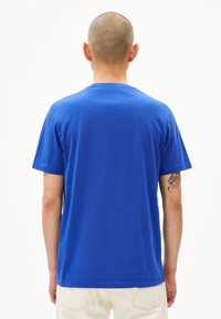 Blaues Baumwoll-T-Shirt mit Rundhalsausschnitt und kurzen Ärmeln, schlichtes Design, glatte Textur und Rückansicht ohne zusätzliche Details.