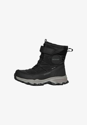 Bota de invierno negra con tobillo alto, correa de velcro, suela gruesa gris, materiales de tela y sintéticos, y tira para tirar en el talón y la parte superior.