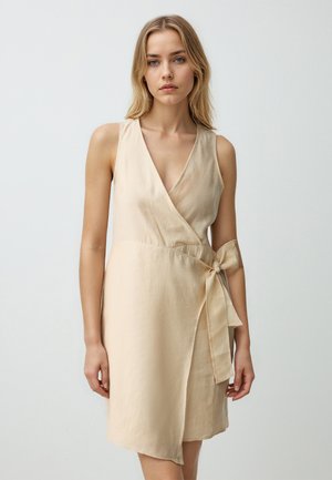 Beige Wickelkleid mit tiefem V-Ausschnitt, ärmellosem Design und einer Bindegurtdetail in der Taille. Hergestellt aus leichtem Stoff mit glatter Textur.