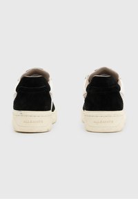 Černobílé semišové sneakers s texturovaným povrchem, krémovou gumovou podešví a decentním brandováním na patě. Nízký střih s kulatou špičkou.