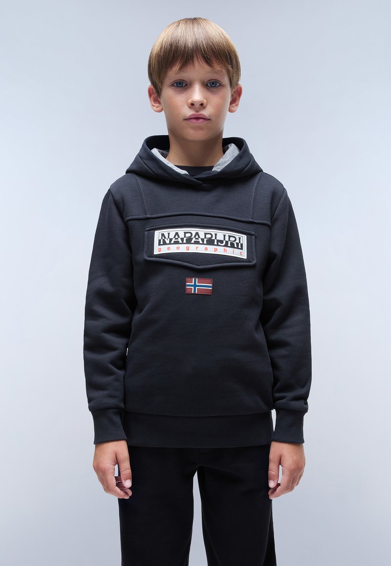 Felpa nera realizzata in cotone misto, con un logo patch frontale, foderata in grigio e un piccolo dettaglio con la bandiera norvegese. Indossata con pantaloni neri.