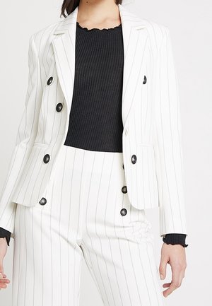 White pinstripe blazer with black buttons over a black ribbed top, paired with matching white pinstripe trousers.