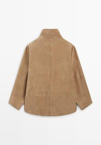 Béžová semišová bunda s vysokým límcem, dlouhými rukávy a švem uprostřed zad, položena na bílém pozadí.