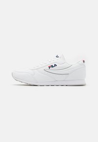 Hvit sportsko laget av syntetisk lær, med lavt design, snøring og Fila-logo detaljer i rødt og blått. Tynn gummisåle.