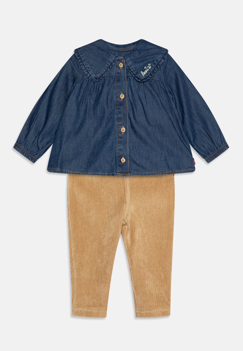 Denim top with a large collar, button-down front, and green embroidery; paired with soft, light brown corduroy pants in a ribbed texture.