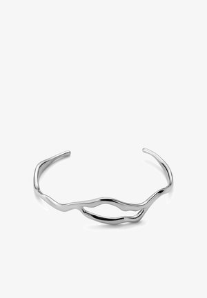 Sølv åbent manchetarmbånd med et abstrakt, uregelmæssigt bølget design og en glat, poleret finish.