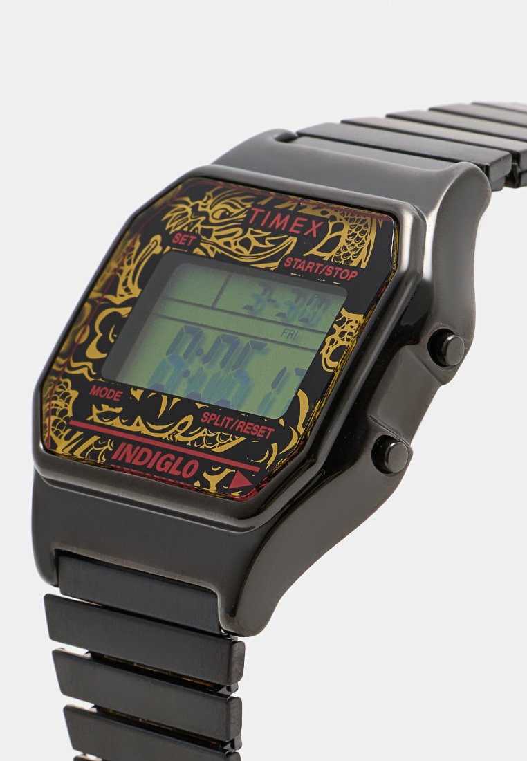 Reloj digital Timex negro con cara hexagonal, que presenta un diseño colorido de dragón, pantalla LCD y correa de eslabones metálicos.