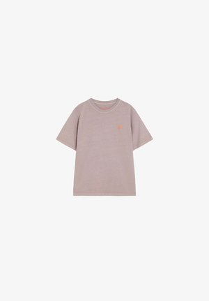 Camiseta beige de manga corta con cuello redondo y pequeño logo naranja en el pecho izquierdo, mostrada sobre un fondo blanco.