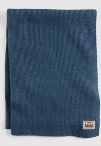 Cachecol de malha em azul escuro, com textura canelada. Inclui uma pequena etiqueta com "Levi Strauss & Co." no canto inferior direito.