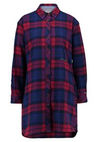 Röd och blå rutigt flanellklänning, långa ärmar, knappframslutning, med en något krökt fåll och logotypaccent nära botten.