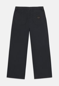 Pantalons larges noirs en coton avec une texture lisse. Comprend deux poches arrière et une étiquette de marque au-dessus de la poche droite.