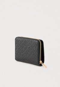 Portefeuille noir avec fermeture zippée, en cuir texturé, présentant un motif géométrique et une quincaillerie en métal doré. Forme rectangulaire compacte.