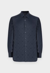 Camicia blu navy con bottoni e maniche lunghe, caratterizzata da un motivo tessurizzato di piccole forme a V, realizzata in un tessuto morbido.