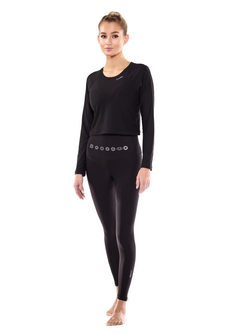 Black long-sleeve top and leggings set made of smooth, stretchy fabric. Leggings feature a decorative waistband design and fitted silhouette.