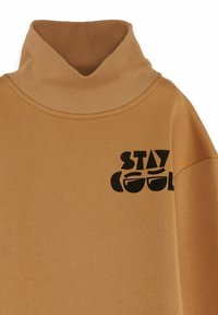 Beige turtleneck sweatshirt med ribbat krage, med en svart grafik som läser "STAY COOL" på framsidan. Mjuk tygkänsla.