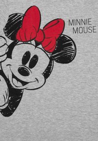 T-shirt grigia con una grafica in bianco e nero di un personaggio dei cartoni animati con un fiocco rosso, con la scritta "MINNIE MOUSE" in lettere in grassetto.