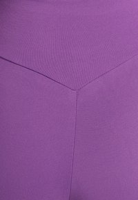 Lila sömlösa leggings med en slät yta, utrustade med en unik chevrondesign vid midjan och en figurnära siluett.