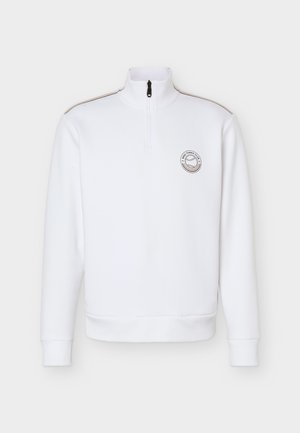 Sweat-shirt blanc à manches longues avec fermeture éclair quart de zip, col haut, fermeture éclair noire, fines bandes beiges sur les épaules, et petit logo du club de tennis sur la poitrine.