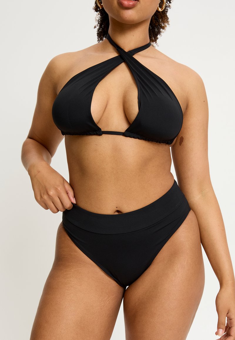Bikini noir avec un haut à licou, des bretelles croisées et un décolleté plongeant, associé à un bas taille haute pour une silhouette élégante.
