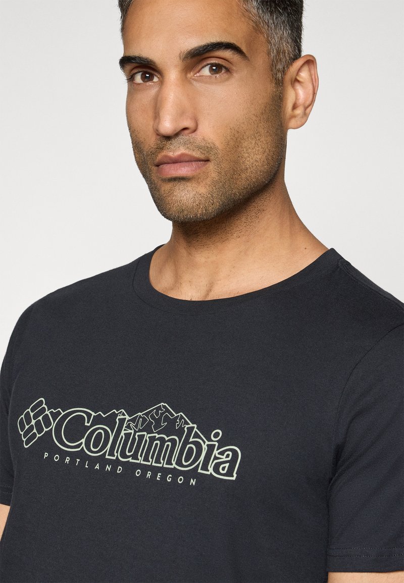 Schwarzes Baumwoll-T-Shirt mit einem hellgrünen "Columbia"-Logo und Berggrafiken, Rundhalsausschnitt und kurzen Ärmeln.