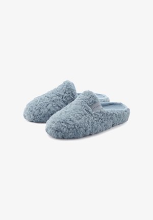 Blaue flauschige Hausschuhe mit einer strukturierten, samtigen Außenseite und einem weichen Innenfutter. Sie haben ein einfaches Design mit einem Akzentetikett an der Seite.