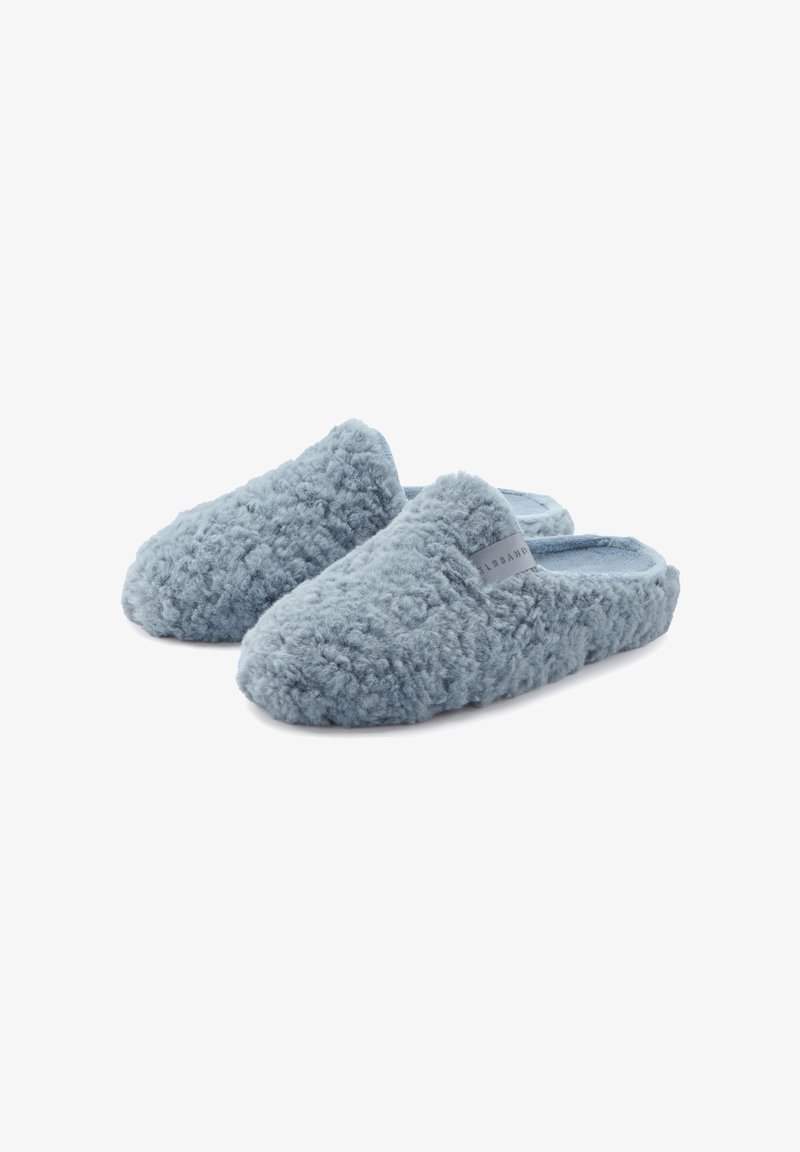 Blue fuzzy slippers with a textured, plush exterior and soft inner lining. Feature a simple design with an accent label on the side.