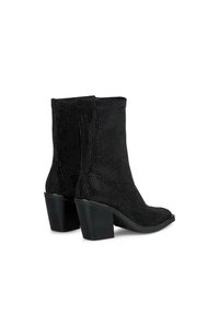 Bottines noires en tissu texturé avec une surface perlée. Elles présentent un bout carré et des talons blocs épais et sombres pour plus de stabilité.