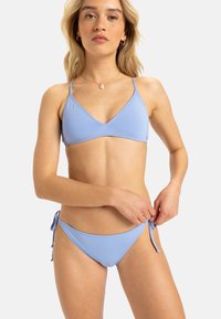 Világoskék bikini szett, háromszög alakú felsőrésszel és állítható oldalt megkötős alsó résszel, sima, rugalmas anyagból készült. Minimális hardver kiegészítők.