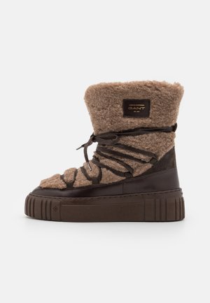 Boot featuring a brown wool upper, a textured surface, and a dark brown synthetic base with a thick platform sole and laces.