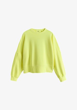 Felpa corta gialla in tessuto morbido, con maniche lunghe, scollo rotondo e polsini a costine con un dettaglio di cucitura sottile.