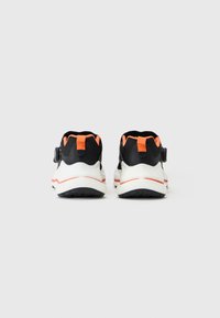 Schwarze und orange Sport Schuhe mit einem Obermaterial aus Mesh, weißen Sohlen und einer strukturierten schwarzen Außensohle. Mit Ziehschlaufe und verstellbarem Riemen.